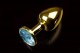 Маленькая золотистая анальная пробка с голубым кристаллом - 7,5 см.